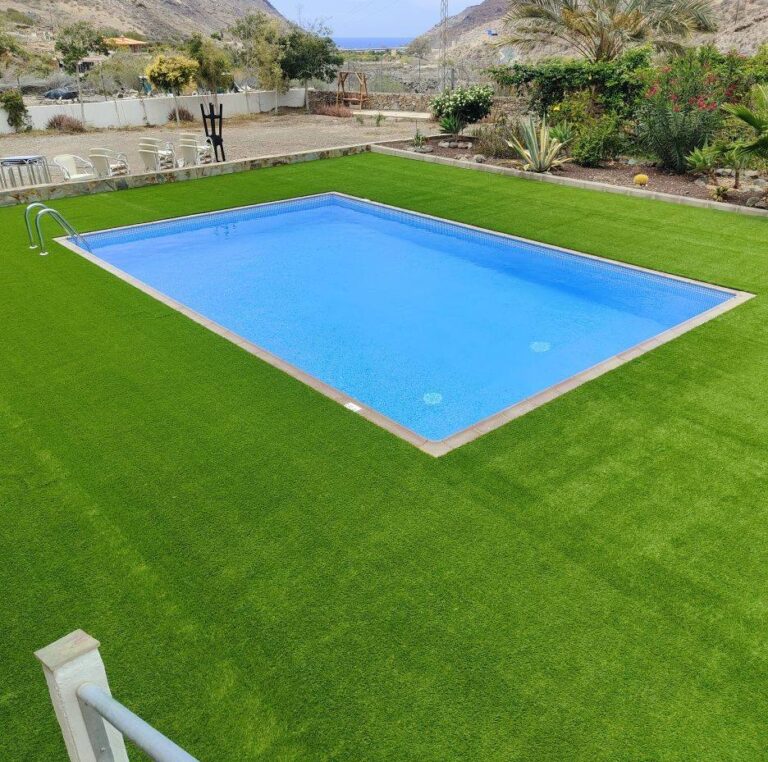 Césped artificial instalado alrededor de una piscina rectangular en Canarias
