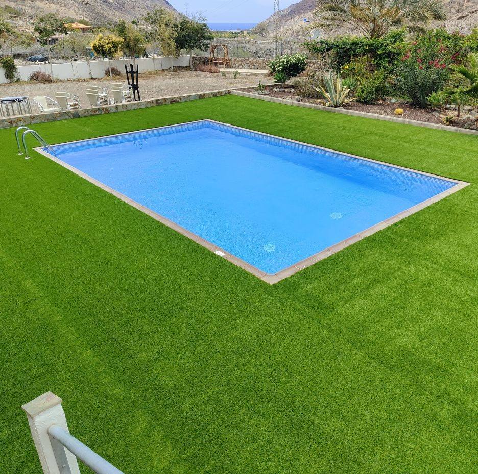 Césped artificial instalado alrededor de una piscina rectangular en Canarias